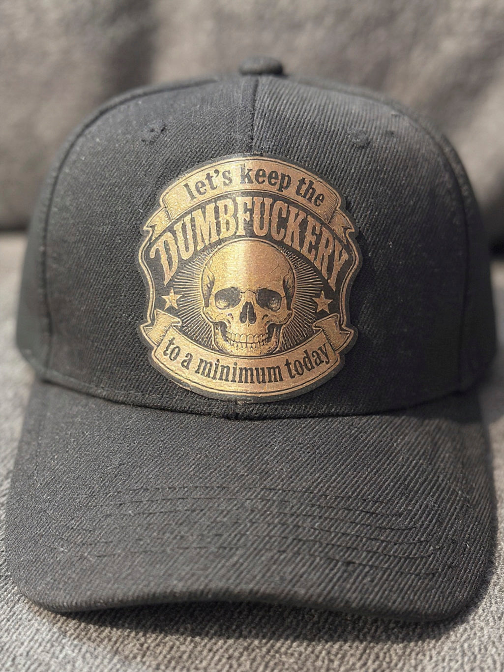 trucker hat with our Dumbfuckery patch in black and copper leather patch