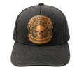 A dark charcoal gray snapback cap featuring a circular tan embroidered patch on the front with a skull graphic and the text 'Let's keep the DUMBFUCKERY to a minimum today'.
